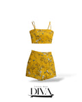 Mustard yellow floral two-piece set featuring a cropped cami top and high-waisted mini skirt with delicate botanical print.