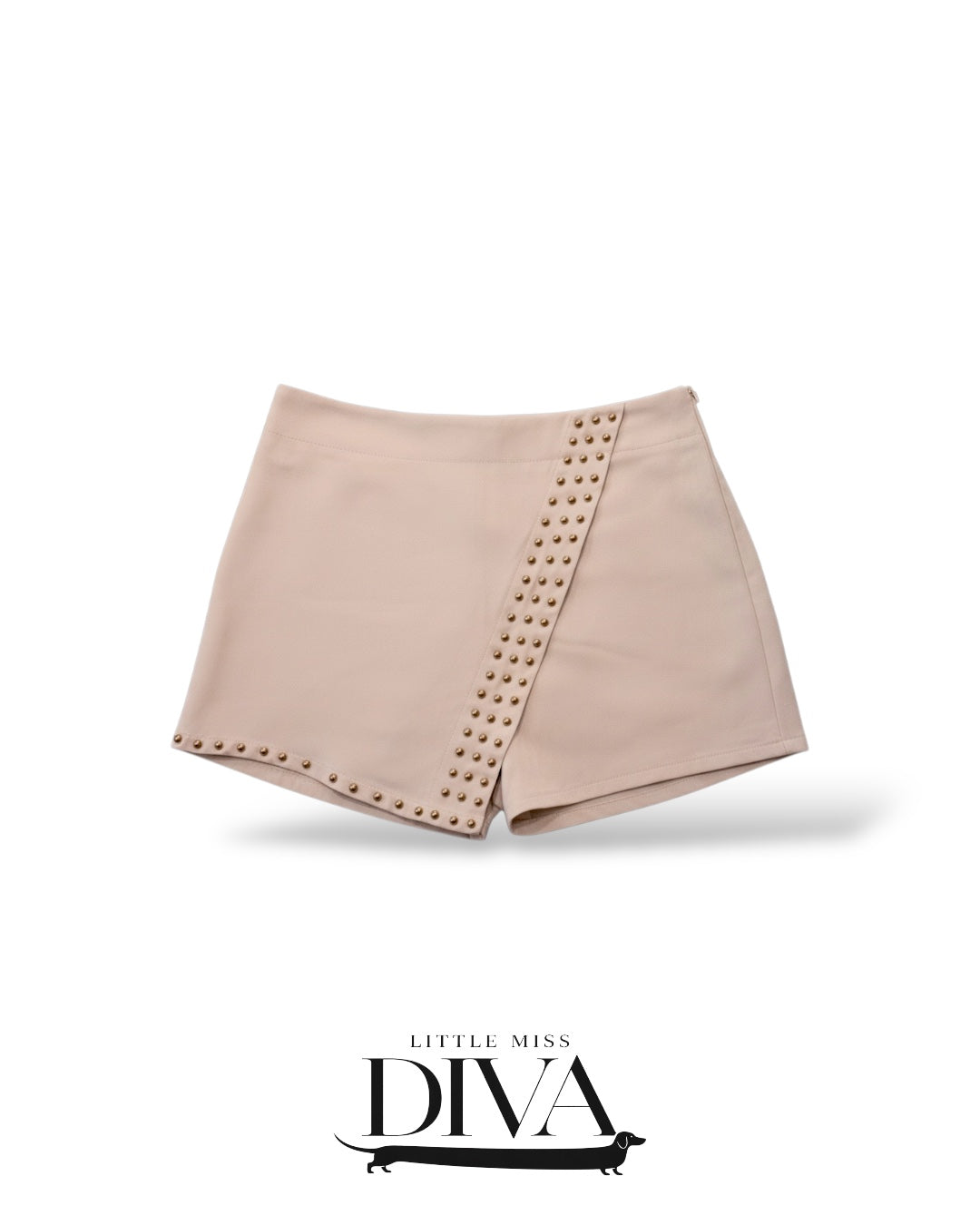 Beige studded skort featuring wrap-style front and gold-tone stud detailing along seams